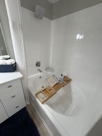 A white bathroom with a white tub and a white shower curtain.